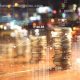 Double explosure with businesss charts of graph and rows of coins for finance at night city background.